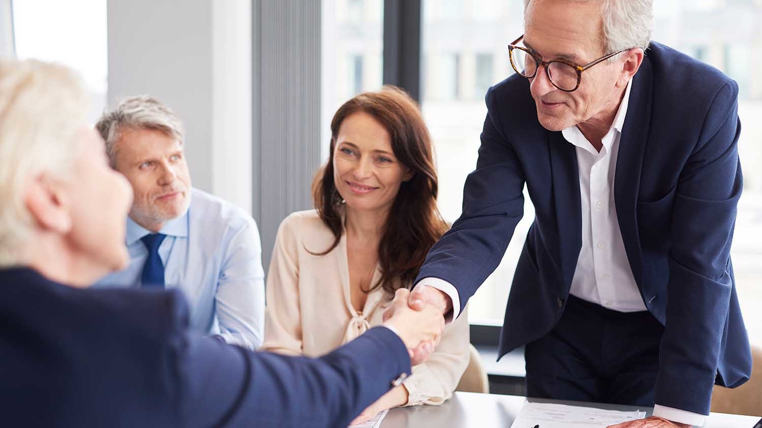 two men shaking hands across a table