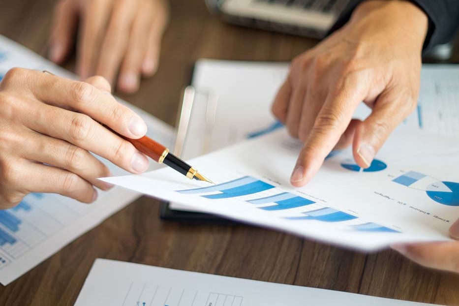 close up of two people referencing a bar graph